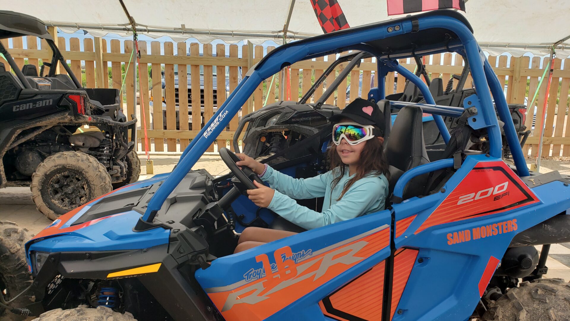 A girl in the driver 's seat of an atv.