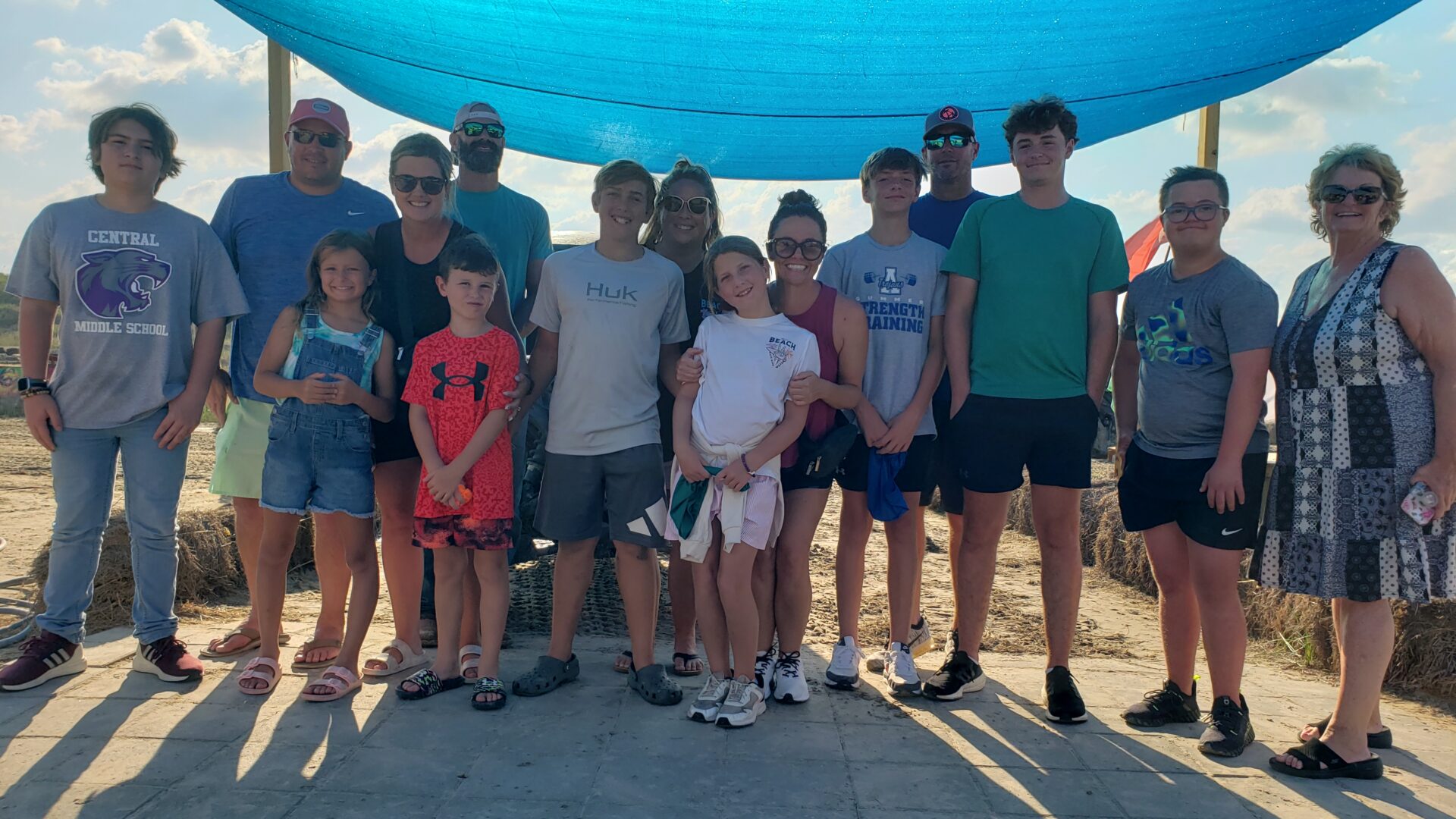 A group of people standing under an umbrella.